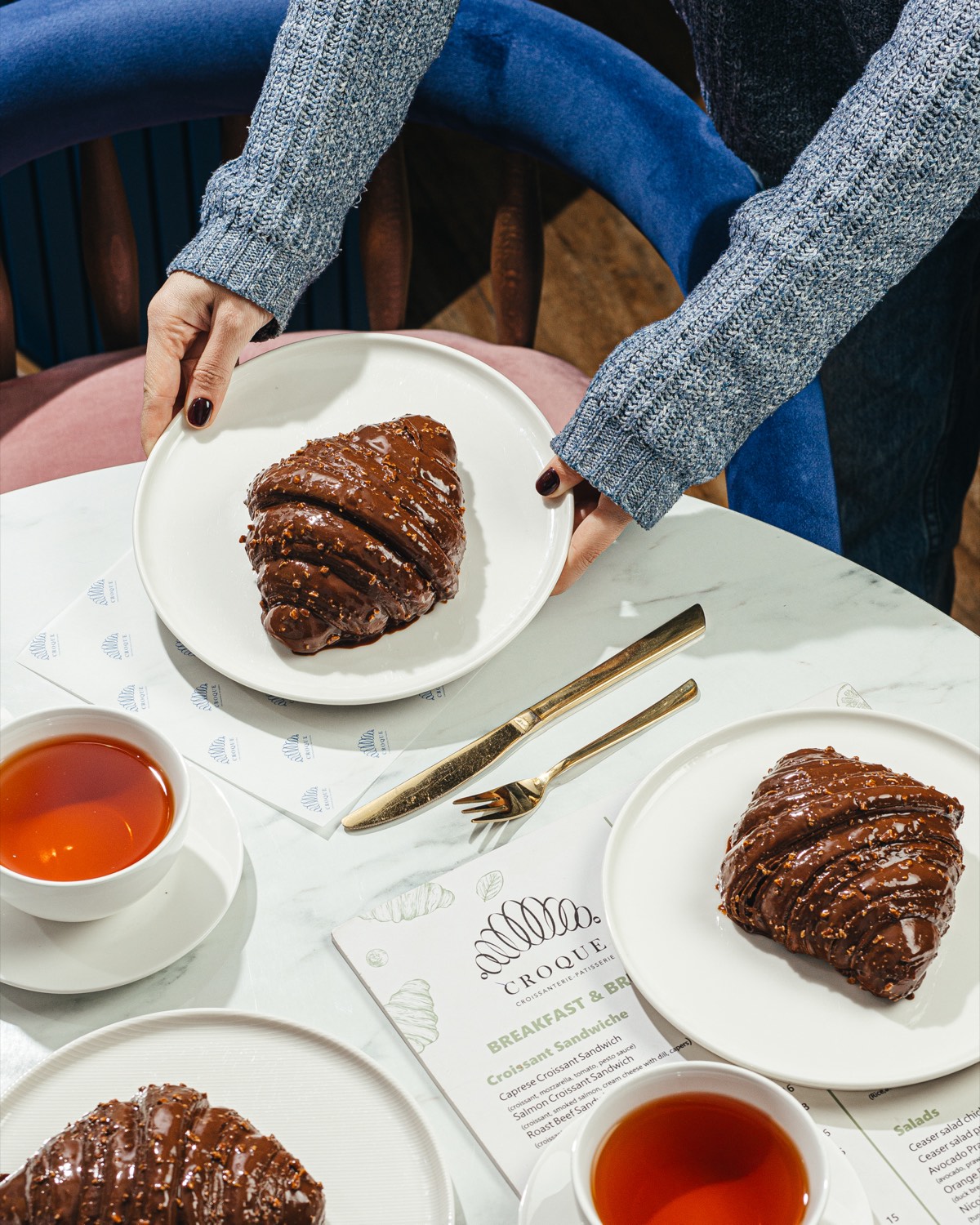Chocolate croissants and tea on marble at Croque, Baku